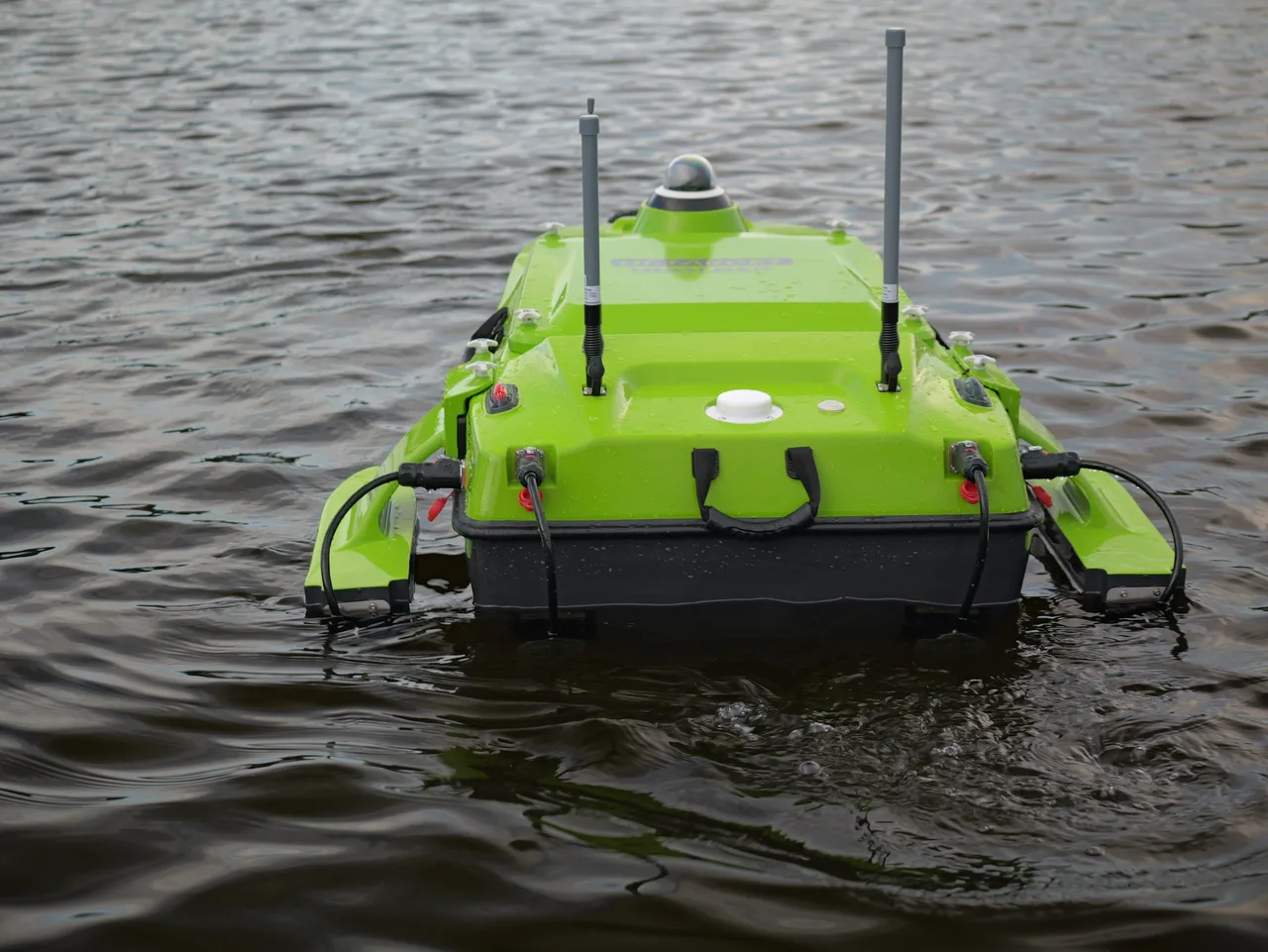 USV Hi-Target iBoat BS15 visto de frente na água, com as duas antenas de comunicação e os flutuadores laterais.