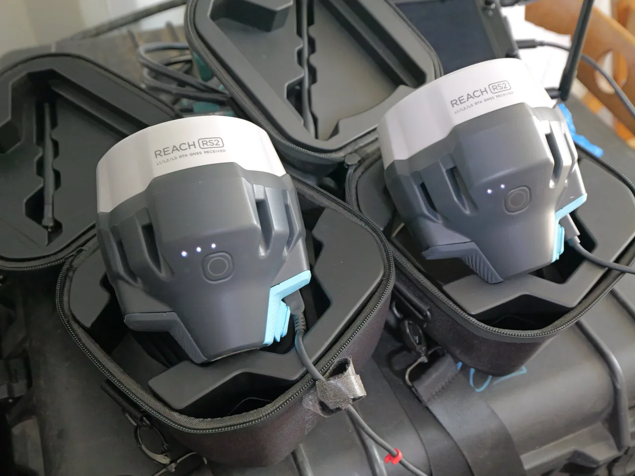Dois receptores GNSS Emlid Reach RS2 acomodados nos cases de transporte.