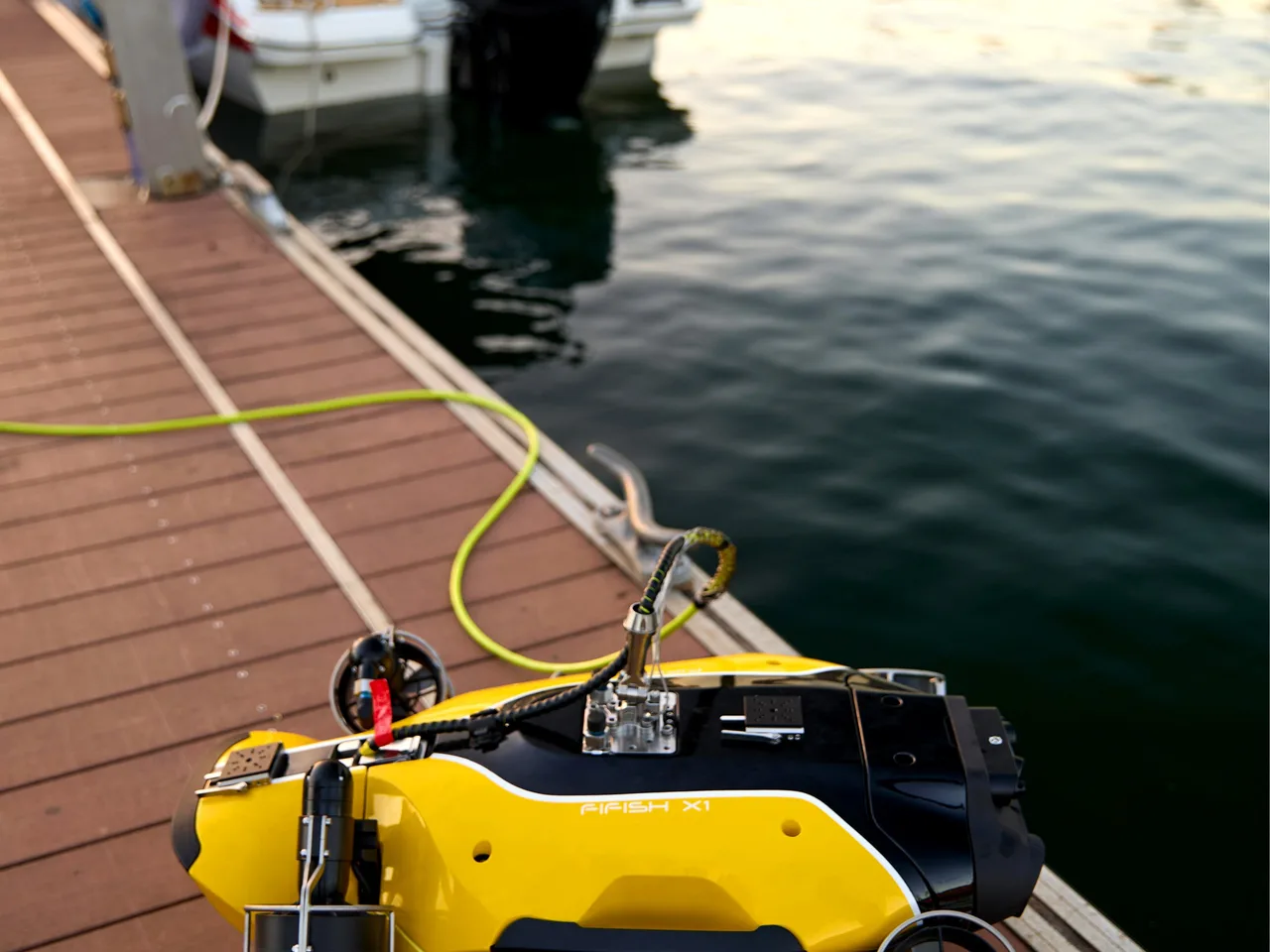 ROV QYSEA FIFISH X1 na borda do pier, conectado ao cabo umbilical.