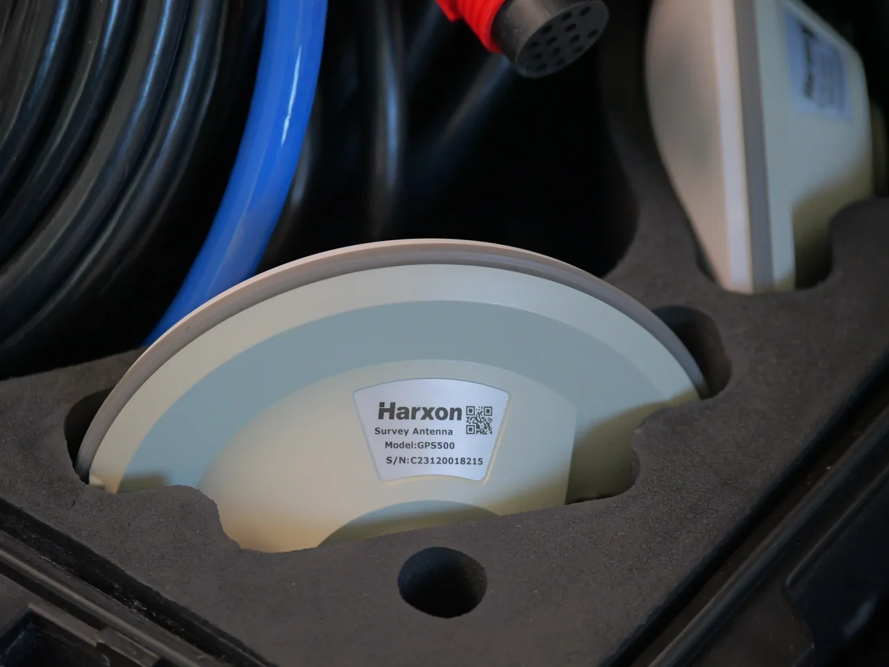 Antena GNSS de levantamento Harxon acomodada na espuma do case de transporte.