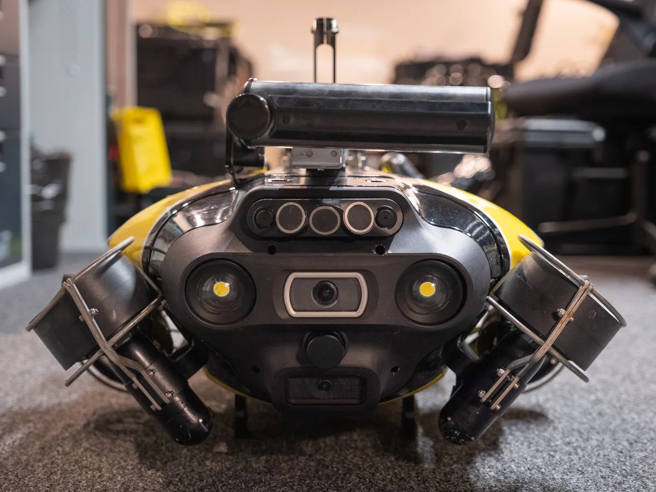 Vista frontal do ROV QYSEA FIFISH X1, com câmeras e iluminação, e o sonar de varredura lateral montado sobre o veículo.