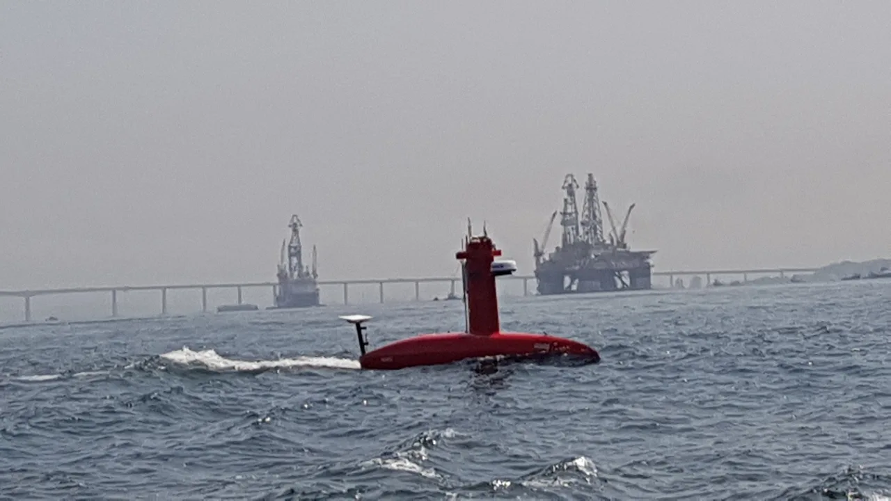 USV Exail DriX em operação na Baía de Guanabara, com plataformas e a Ponte Rio-Niterói ao fundo