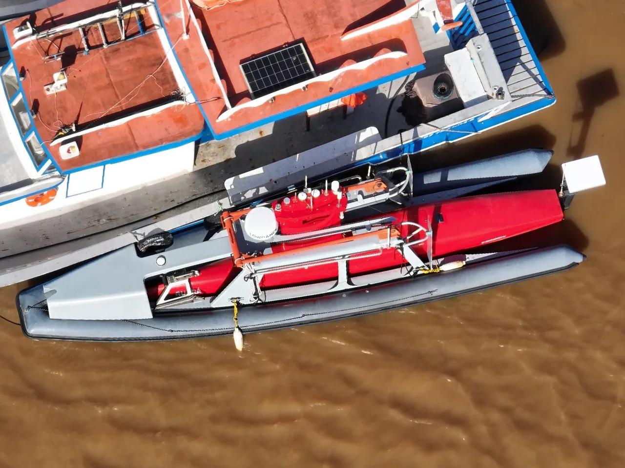 USV Exail DriX atracado ao lado da embarcação de apoio, visto do alto.