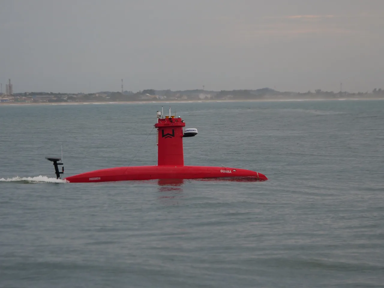 USV Exail DriX em navegação próximo à costa, visto de lado.