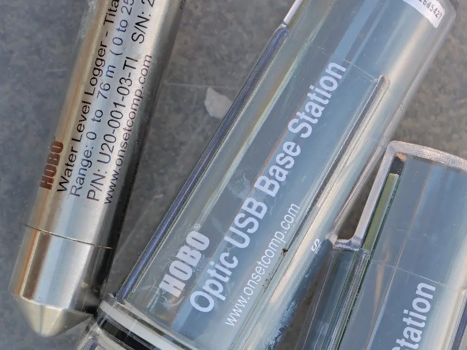 Registrador de nível HOBO em titânio ao lado da estação óptica USB.