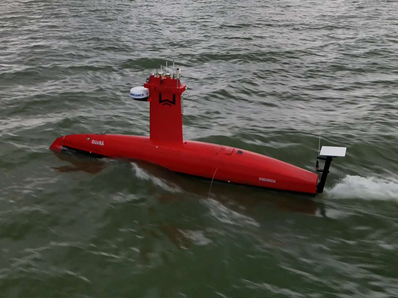 USV Exail DriX em navegação visto do alto, com o mastro e a antena GNSS de popa.
